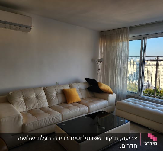 ספה לבנה עם כריות צבעוניות בחדר מואר